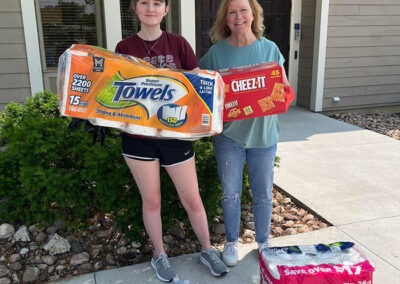 A teen and middle-aged woman showcase donations to CACCMO.